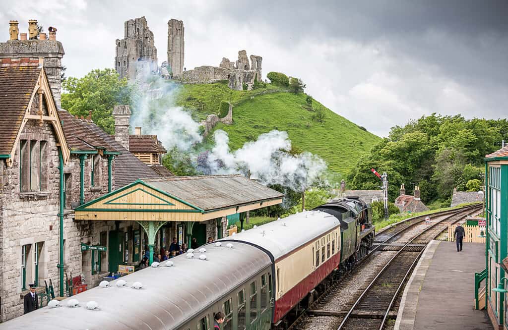 Corfe Castle Train Station and the castle in the background- one of the best places to visit in Dorset